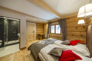 a bedroom with a large bed and a bathroom at Pompelówka - chata na Głubałówce in Zakopane