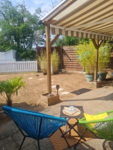 a patio with chairs and a table under a pergola at ELLE Loc St-Brévin in Saint-Brevin-les-Pins