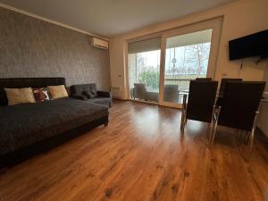 a living room with a bed and a table at Piano Balaton Apartment in Zamárdi