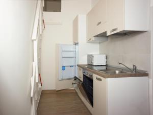 een kleine witte keuken met een wastafel en een koelkast bij UniHome Napoli in Napels
