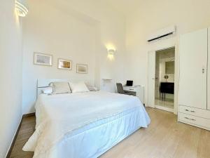 een witte slaapkamer met een wit bed en een bureau bij UniHome Napoli in Napels