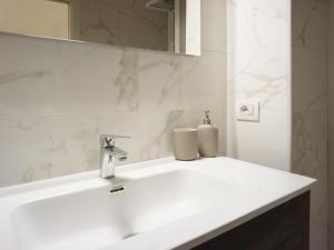 een badkamer met een witte wastafel en een spiegel bij UniHome Napoli in Napels +13 foto's