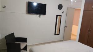 a bedroom with a bed and a tv on the wall at Casa Comoda y Bonita en Caucel Merida in Mérida