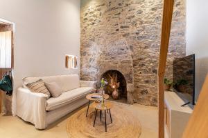 a living room with a couch and a stone fireplace at Olivetta ,Traditional stone house in Kos Town