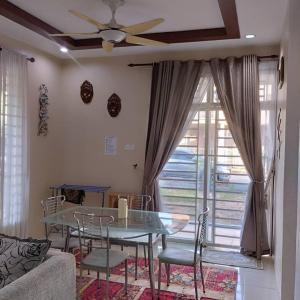 sala de estar con mesa, sillas y ventilador de techo en Aman Homestay Anak Bukit, en Alor Setar 11 fotos más