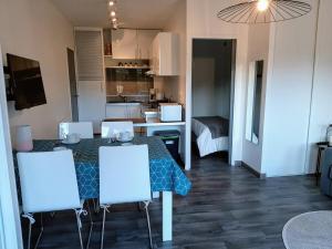 a kitchen and living room with a table and chairs at Le Royal Parc - Appartement au calme au coeur de Bénodet in Bénodet