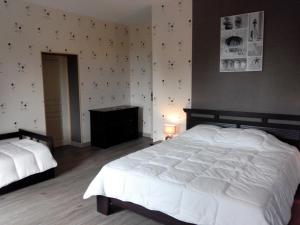 a bedroom with two white beds and a wall at Chambres d'hôtes -- Le Clos de Gémozac in Gémozac