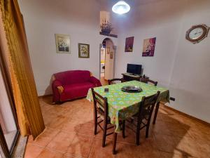 a living room with a table and a red couch at Casa Vacanze Sa Petra Ruja La Caletta di Siniscola in Siniscola
