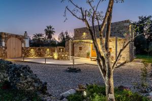 a stone house with a courtyard with a tree at Olivetta ,Traditional stone house in Kos Town