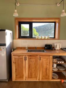 eine Küche mit Spüle und Fenster in der Unterkunft Cabaña Lilacho in Cholila + 11 Fotos