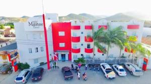 un grupo de autos estacionados en un estacionamiento frente a un edificio en Hotel Master, en Jequié