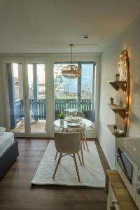 a living room with a table and chairs in a room at Surfers Studio with Beach, near Interlaken and Grindelwald in Därligen
