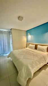 ジェキエーにあるHotel Masterの青い壁の客室で、白い大型ベッド1台が備わります。