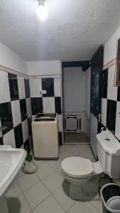 a bathroom with a white toilet and a sink at Villa Dewdrops in Hikkaduwa