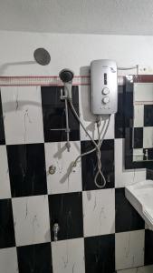 a bathroom with a blow dryer on the wall at Villa Dewdrops in Hikkaduwa +1 photo