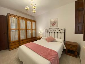 a bedroom with two beds and a chandelier at Apartamentos Oreña in Oreña