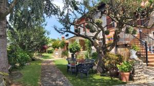 a garden with chairs and a table under a tree at Apartamentos Oreña in Oreña
