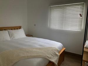a bedroom with a large bed with a window at Chalet K94 - Sunset View in Camber +27 photos