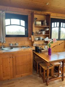 una cucina con mobili in legno e un tavolo in legno di Les Roulottes des Amis de Wonky a Rétaud Altre 21 foto