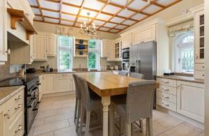 a large kitchen with a wooden table and appliances at Moyvannan Castle on 7 Acres in Roscommon