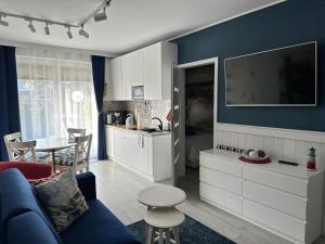 kuchnia i salon z niebieską ścianą w obiekcie Amko Style Apartamenty Nord 8 z ogródkiem Willa Nord w Jastrzębiej Górze