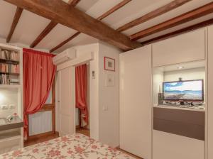 1 dormitorio con 1 cama y TV en la pared en Sitornino Apartment, en Florencia