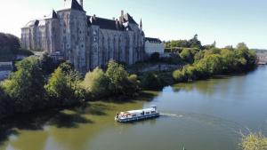 a boat on a river in front of a large building at La petite maison in Solesmes +8 photos