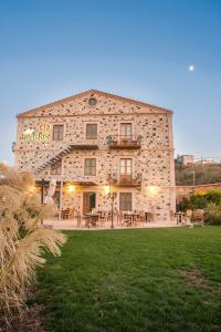 a large stone building with tables and chairs at Cunda Labris Hotel in Ayvalık