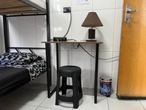 una camera da letto con una scrivania e uno sgabello accanto al letto di Quartos na Praia - Cozinha Compartilhada, Self Check-in, WiFi, Próximo à Praia a Santos Altre 35 foto