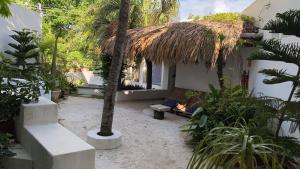 un cortile con un edificio dotato di panchina e palma di Mi Casa en Cozumel a Cozumel
