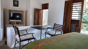 una camera da letto con un letto, un tavolo e delle sedie di Mi Casa en Cozumel a Cozumel