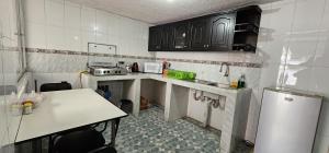 a small kitchen with a table and a refrigerator at Departamento Tulcán in Tulcán