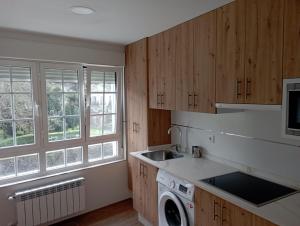 a kitchen with a sink and a washing machine at La Fuente in Luarca