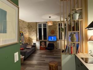 a living room with a couch and a table at Charmant studio avec terrasse hyper-centre de Vannes à 5 min du Port et des Remparts in Vannes