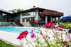 a house with a swimming pool and pink flowers at Lodges at Sunrise 3BR 3BA Luxury Ski On Ski Off Condo, Pool, Hot Tub, Gym, Sports Center in Killington