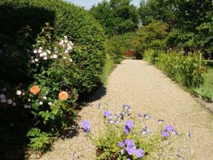 a garden with flowers on a gravel path at Chambres d'Hôtes La Sauvageonne in Saint-Palais