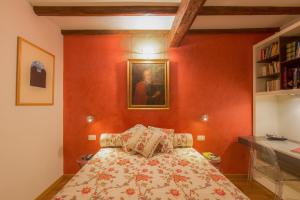 1 dormitorio con 1 cama con una pintura en la pared en Sitornino Apartment, en Florencia