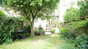 a garden with a tree and a house at Malo Les Bains House & Beach Garden 5 min walk in Malo-les-Bains +10 photos