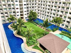 an aerial view of a resort with a pool and palm trees at Wowstaycation in Manila