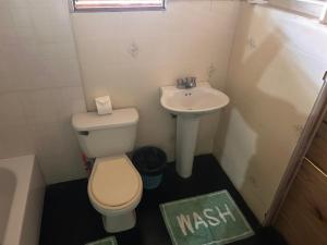 a small bathroom with a toilet and a sink at 3Dives Cliffside Rooms in Westlands