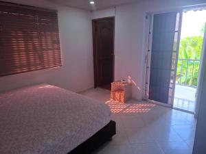 a bedroom with a bed and a door to a balcony at Casa Lisboa in San Andrés