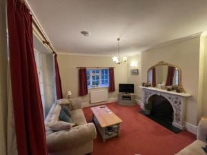 a living room with a couch and a fireplace at Woodlands in Ventnor