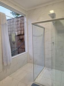 a glass shower in a bathroom with a window at Toca do Gambá in Ubatuba +20 photos