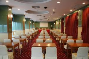 a room with rows of tables and white chairs at Poipet Resort & Casino in Krong Poi Pet