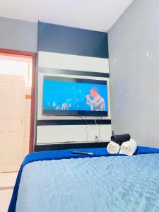 a bedroom with a bed with a tv on the wall at Suíte Pé na Areia in Arraial do Cabo