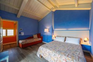 a bedroom with blue walls and a bed and a couch at Florario B&B in Chieri +66 photos