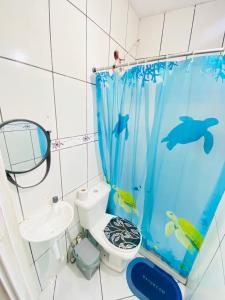 a bathroom with a dolphin shower curtain and a toilet at Suíte Pé na Areia in Arraial do Cabo