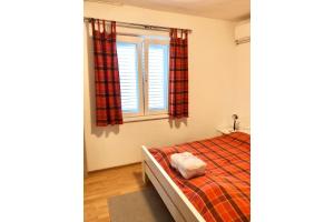 a bedroom with a bed and a window at Apartment Bonaca in Rogoznica