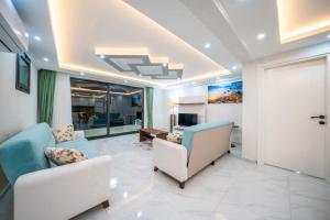 a living room with two chairs and a door at KaşKalkan Deniz manzaralı Havuzlu Bahçeli Villa in Kas