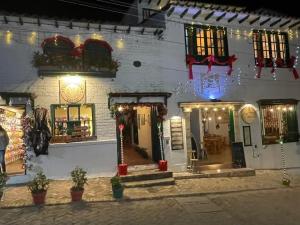 a white brick building with christmas lights on it at VILLA DE MOYA HOTEL MONGUI in Monguí